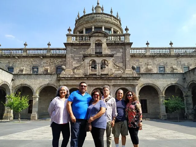 Group of people standing in a courtyard in front of a historic building