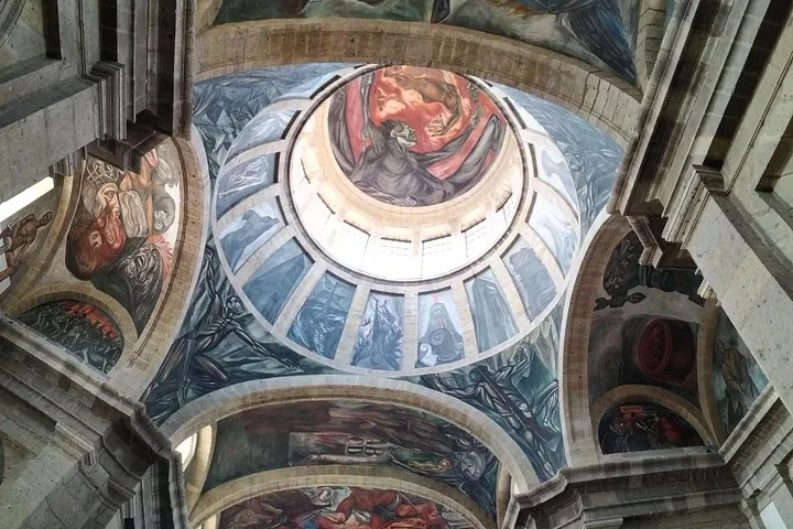 Interior view looking up at a dome covered in dramatic murals