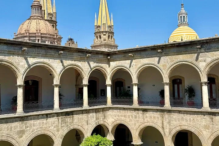 Courtyard with stone arches looking towards the spires of Guadalajara Cathedral